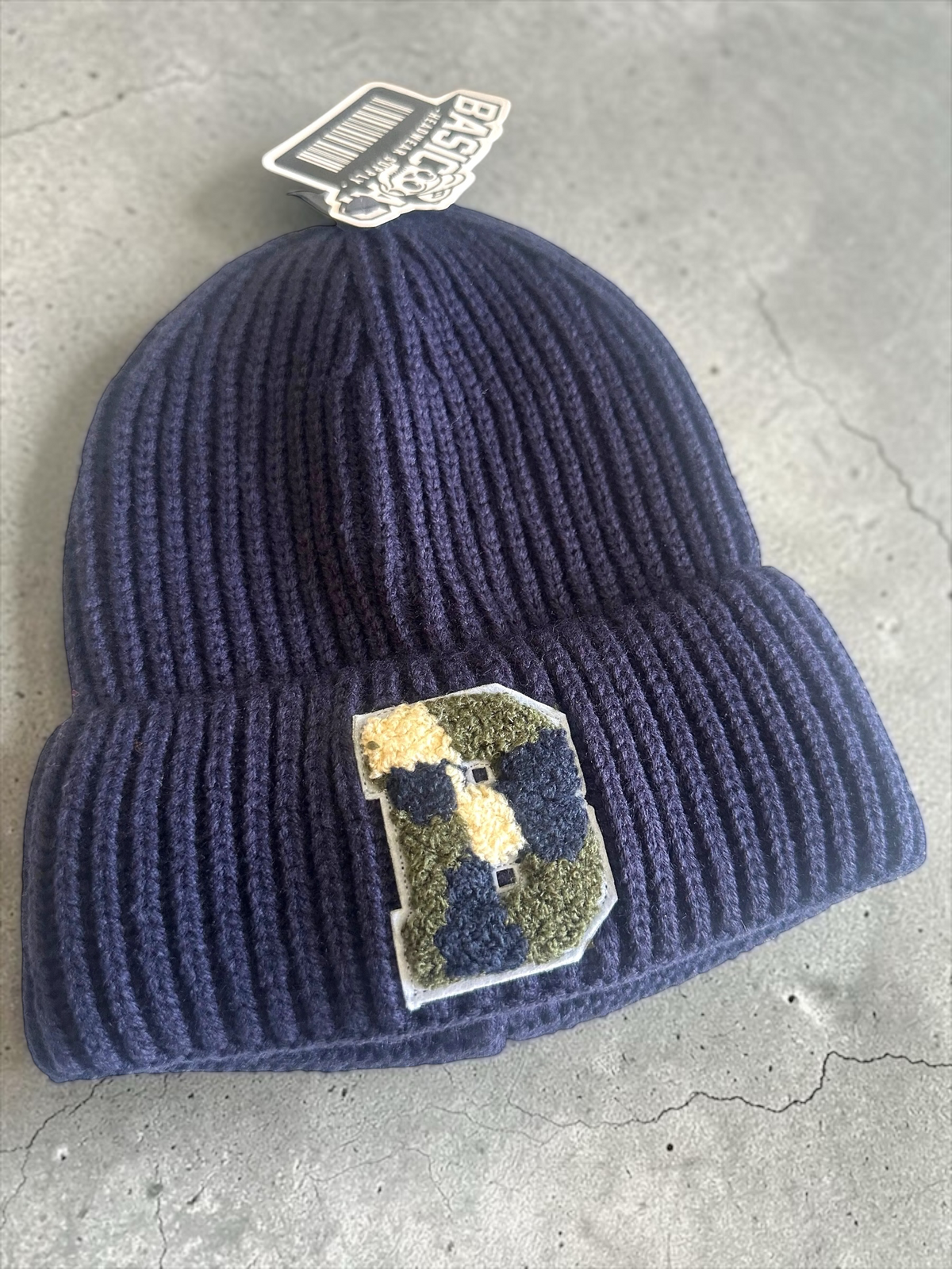 B-Is-TheBrand navy blue ribbed knit winter beanie with a textured collegiate-style letter B patch on the front cuff.